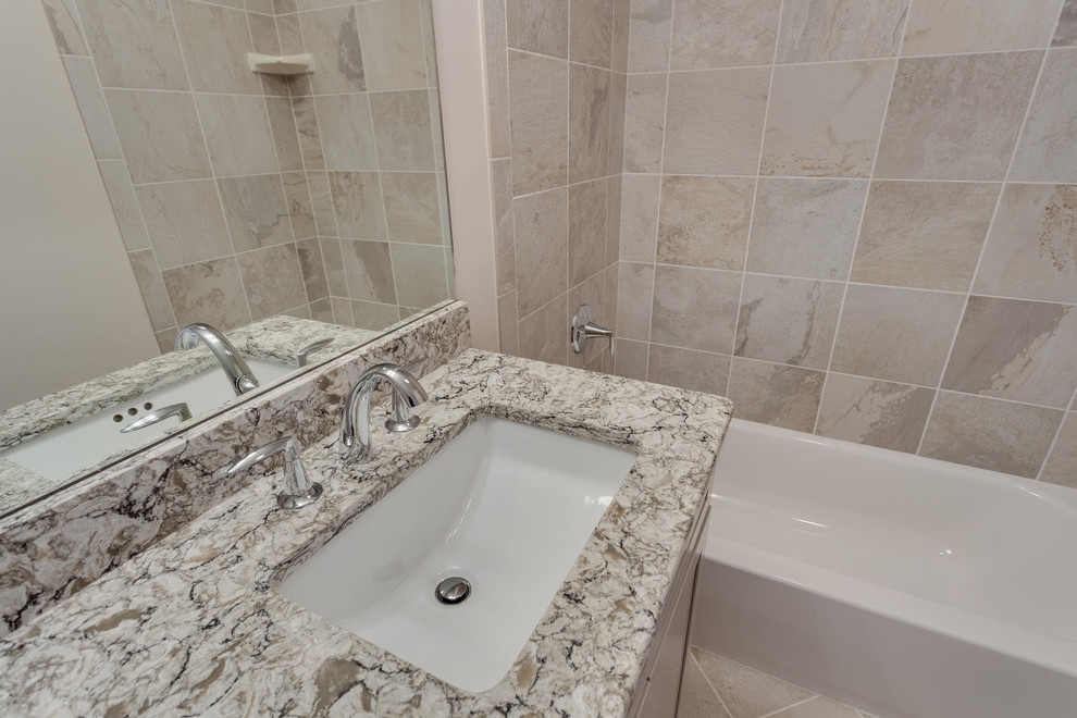 This is an example of a mid-sized traditional bathroom in DC Metro with an undermount sink, shaker cabinets, beige cabinets, engineered quartz benchtops, an alcove tub, beige tile, ceramic tile, beige walls and ceramic floors.