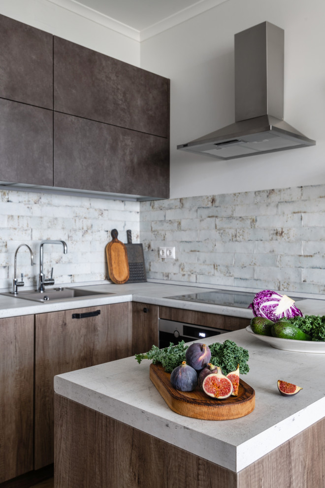 This is an example of a small contemporary u-shaped kitchen in Moscow with a drop-in sink, flat-panel cabinets, medium wood cabinets, white splashback, stainless steel appliances, a peninsula and white benchtop.