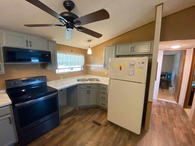 Inspiration for a large l-shaped eat-in kitchen remodel with a drop-in sink, flat-panel cabinets, gray cabinets, laminate countertops, no island and white countertops