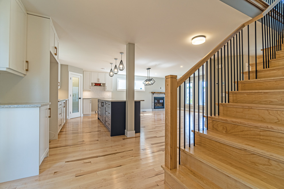 Mid-sized transitional light wood floor and beige floor eat-in kitchen photo with shaker cabinets, white cabinets, granite countertops, an island and gray countertops