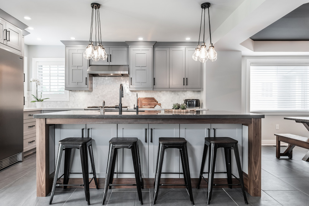Eat-in kitchen - transitional l-shaped gray floor eat-in kitchen idea with an undermount sink, shaker cabinets, gray cabinets, white backsplash, mosaic tile backsplash, stainless steel appliances, an island and gray countertops