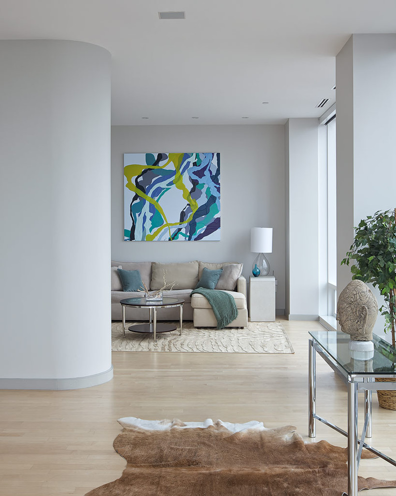 This is an example of a contemporary living room in New York with grey walls, light hardwood floors and beige floor.