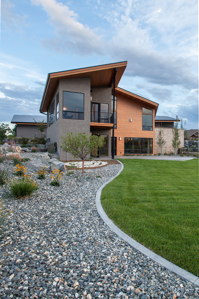 This is an example of a large contemporary two-storey grey exterior in Denver with wood siding and a shed roof.