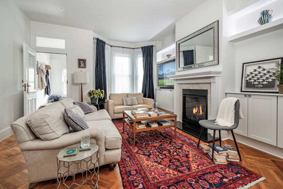 Mittelgroßes, Abgetrenntes Modernes Wohnzimmer mit weißer Wandfarbe, braunem Holzboden, Kamin, Kaminumrandung aus Stein und braunem Boden in Newark