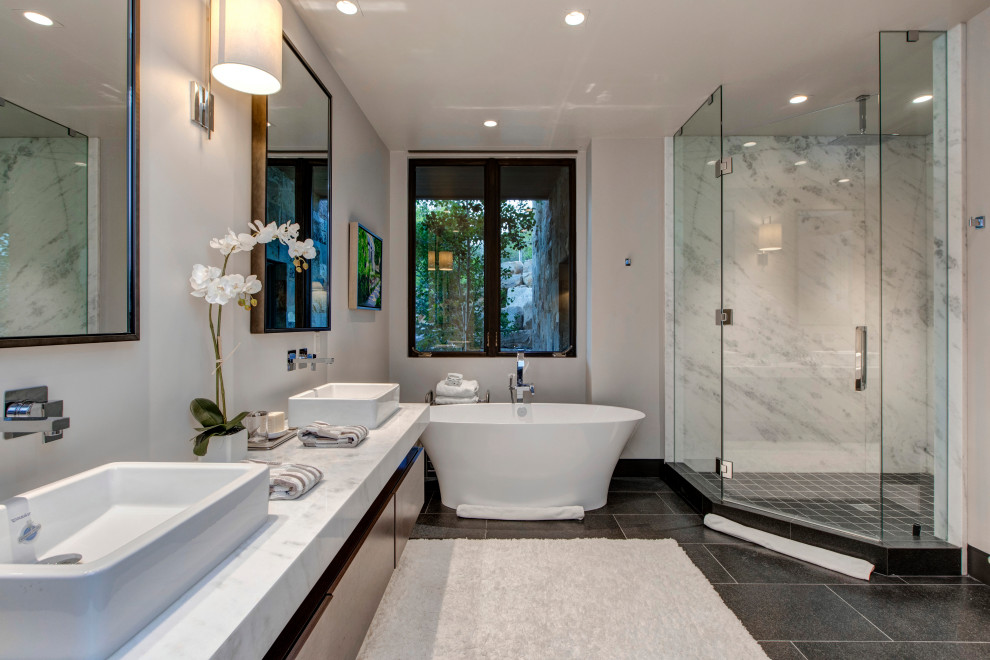 Modelo de cuarto de baño doble rústico grande con armarios con paneles lisos, puertas de armario de madera clara y encimeras grises