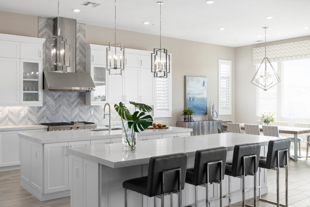 Inspiration for a transitional kitchen in San Diego with an undermount sink, shaker cabinets, white cabinets, quartz benchtops, grey splashback, porcelain splashback, stainless steel appliances, porcelain floors, multiple islands, grey floor and white benchtop.