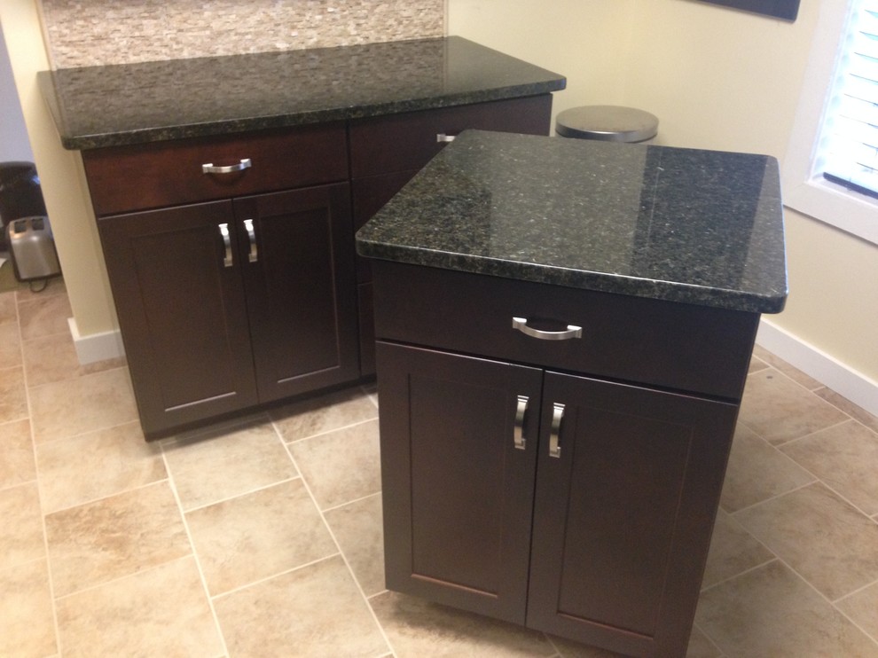 Inspiration for a mid-sized transitional l-shaped porcelain tile enclosed kitchen remodel with an undermount sink, shaker cabinets, dark wood cabinets, granite countertops, beige backsplash, stone tile backsplash, stainless steel appliances and an island