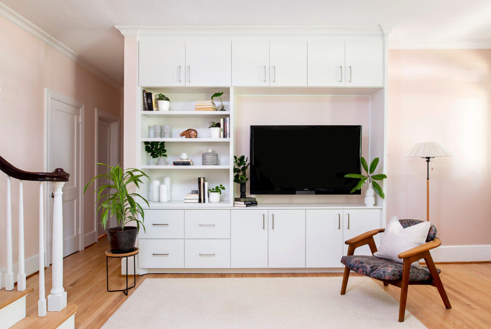 Esempio di un soggiorno design di medie dimensioni e chiuso con pareti rosa, pavimento in legno massello medio e parete attrezzata