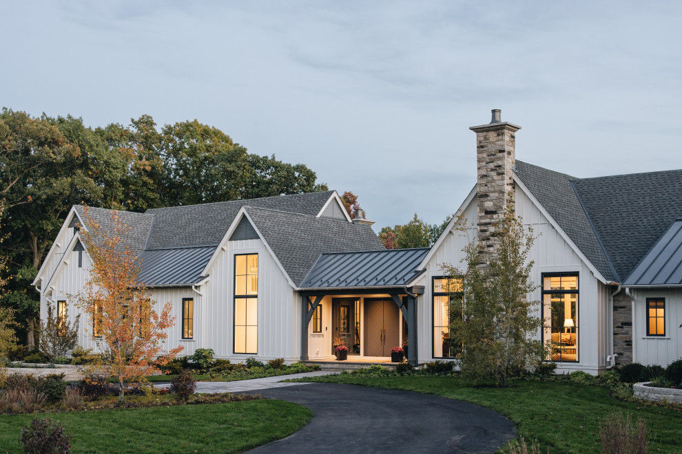 Réalisation d'une grande façade de maison blanche tradition de plain-pied avec un toit à croupette et un toit gris.