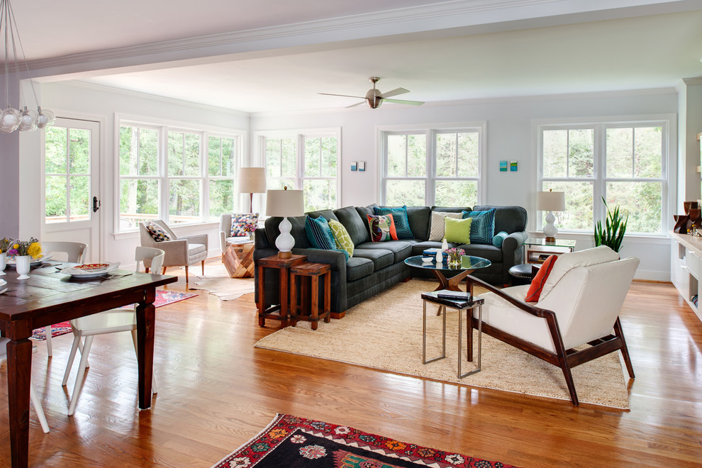 This is an example of a large eclectic open concept family room in Richmond with white walls, medium hardwood floors, no fireplace and a built-in media wall.