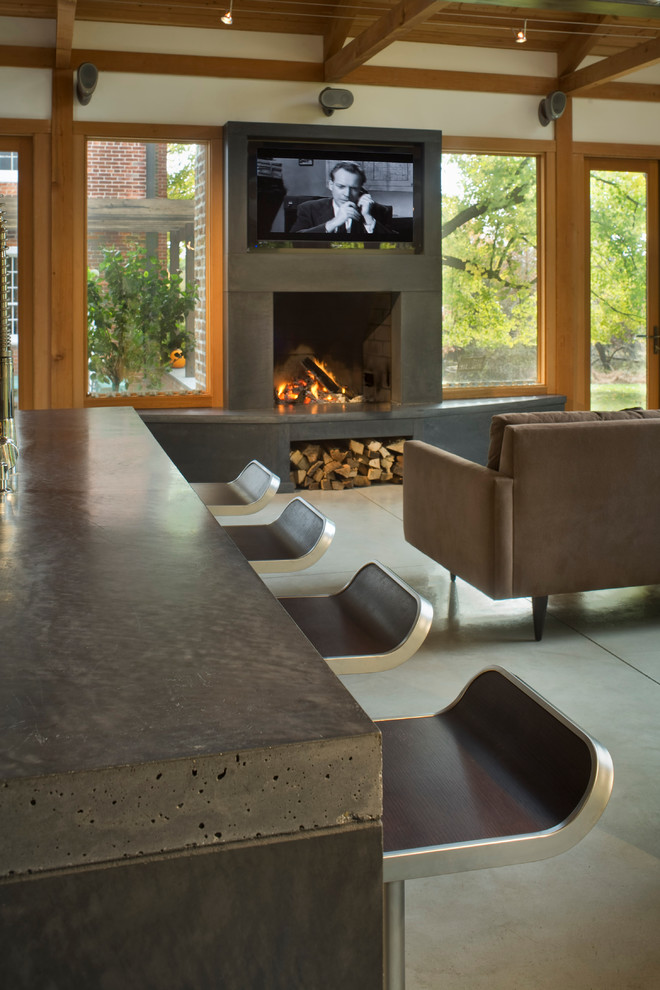 Inspiration for a contemporary living room in New York with a concrete fireplace surround and concrete floors.