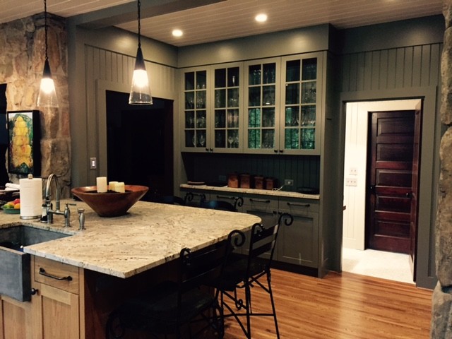 Photo of a large country galley open plan kitchen in Other with a farmhouse sink, shaker cabinets, medium wood cabinets, limestone benchtops, stainless steel appliances, medium hardwood floors and with island.