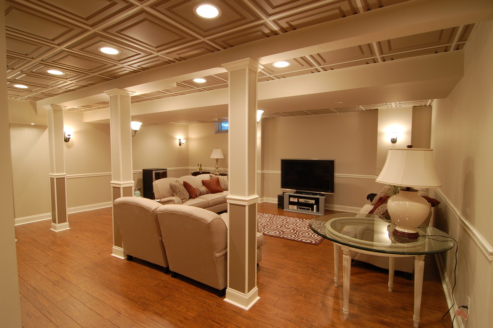 Large contemporary fully buried basement in New York with beige walls, dark hardwood floors, no fireplace and orange floor.