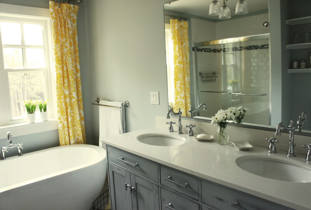 Inspiration for a mid-sized traditional master bathroom in Ottawa with an undermount sink, shaker cabinets, distressed cabinets, solid surface benchtops, a freestanding tub, an alcove shower, a two-piece toilet, white tile, subway tile, blue walls and porcelain floors.