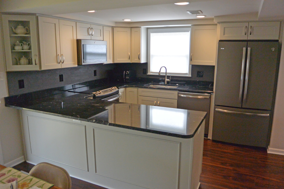 This is an example of a small transitional u-shaped eat-in kitchen in Baltimore with an undermount sink, shaker cabinets, grey cabinets, granite benchtops, grey splashback, mosaic tile splashback, stainless steel appliances, medium hardwood floors, a peninsula, brown floor and grey benchtop.