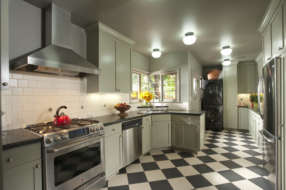 Photo of a traditional separate kitchen in San Francisco with stainless steel appliances, shaker cabinets, green cabinets, white splashback and multi-coloured floor.