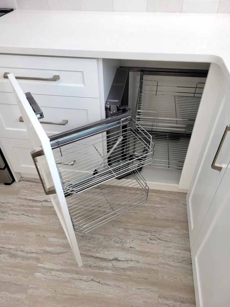 Eat-in kitchen - huge transitional u-shaped vinyl floor eat-in kitchen idea with an undermount sink, white cabinets, quartzite countertops, gray backsplash, stone tile backsplash, stainless steel appliances, an island and white countertops