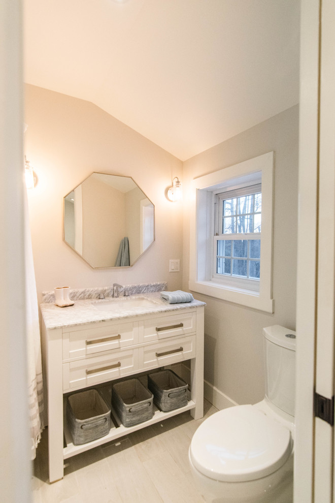 This is an example of a large beach style galley utility room in Montreal with an utility sink, shaker cabinets, white cabinets, quartz benchtops, grey walls, ceramic floors, a side-by-side washer and dryer, grey floor and white benchtop.