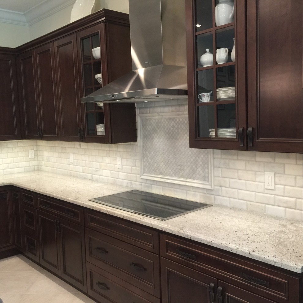 Inspiration for a timeless ceramic tile eat-in kitchen remodel with recessed-panel cabinets, dark wood cabinets, granite countertops, white backsplash, stone tile backsplash and stainless steel appliances