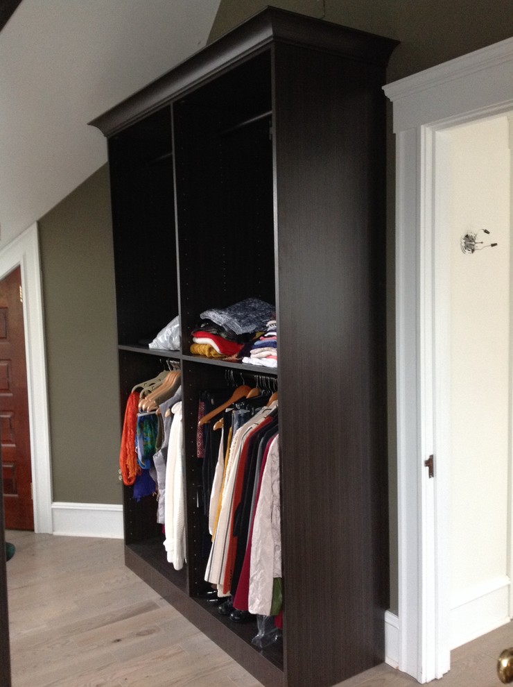Design ideas for a mid-sized modern gender-neutral walk-in wardrobe in New York with open cabinets, light wood cabinets, laminate floors and beige floor.