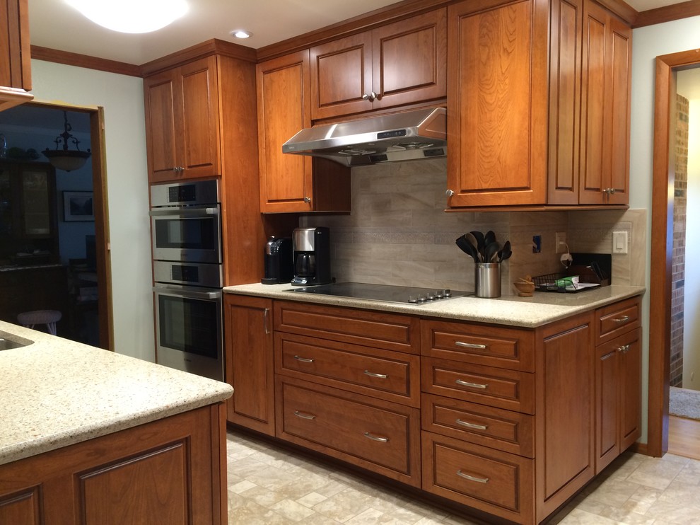 Mid-sized transitional linoleum floor kitchen photo in Seattle with an undermount sink, raised-panel cabinets, medium tone wood cabinets, quartzite countertops, beige backsplash, ceramic backsplash and stainless steel appliances