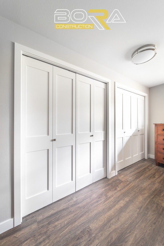 シアトルにある高級な中くらいなおしゃれな壁面クローゼット (シェーカースタイル扉のキャビネット、白いキャビネット、濃色無垢フローリング、茶色い床) の写真