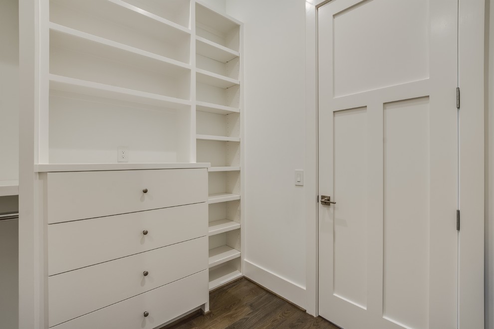 This is an example of a mid-sized midcentury gender-neutral walk-in wardrobe with shaker cabinets, white cabinets, medium hardwood floors and brown floor.