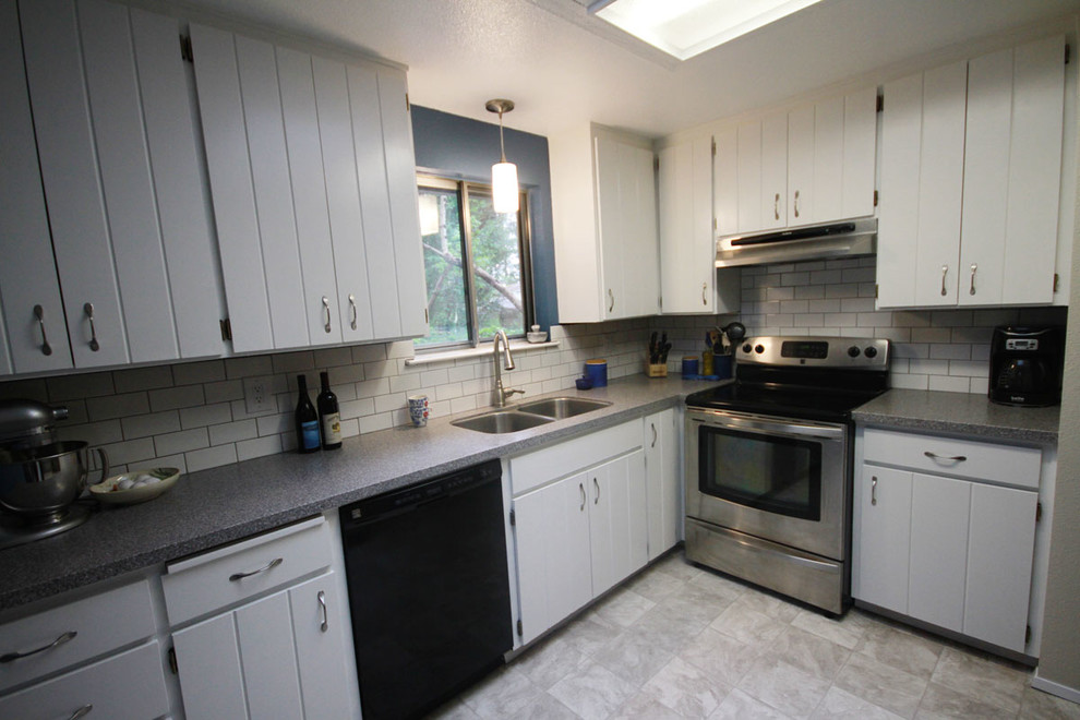 Mid-sized transitional l-shaped linoleum floor enclosed kitchen photo in Seattle with an undermount sink, flat-panel cabinets, white cabinets, solid surface countertops, white backsplash, subway tile backsplash, stainless steel appliances, blue walls and no island