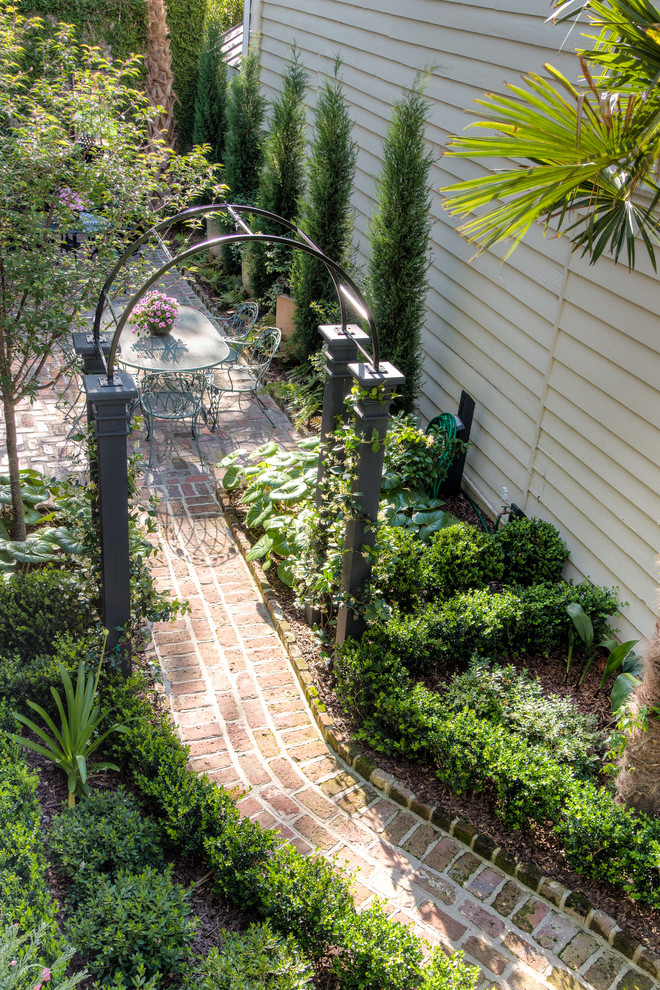 Inspiration for a small traditional courtyard patio in Charleston with a water feature and brick pavers.