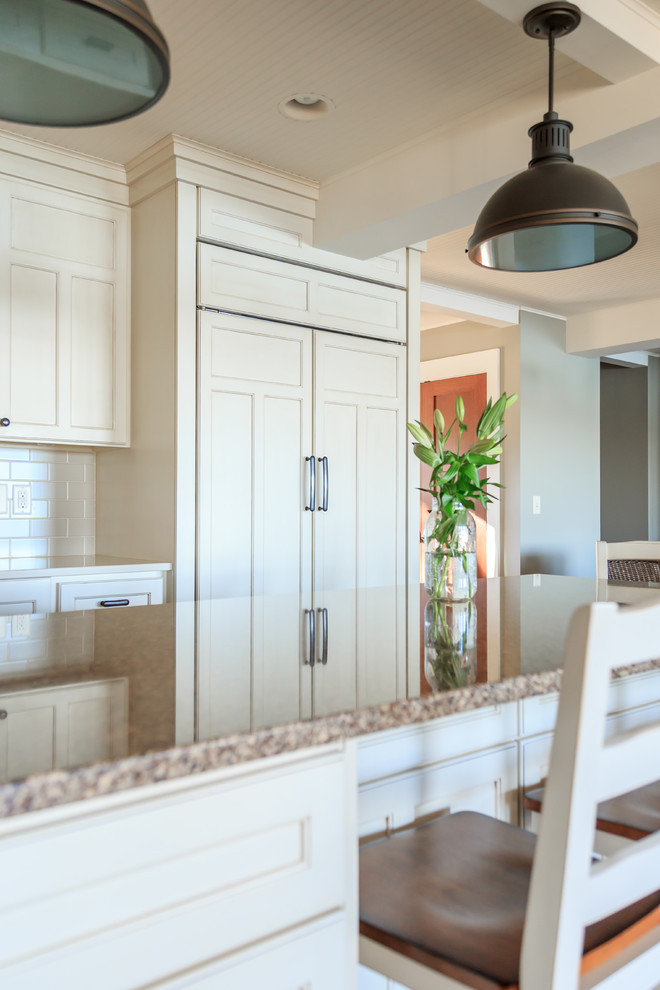 Transitional l-shaped vinyl floor open concept kitchen photo in Minneapolis with an undermount sink, raised-panel cabinets, white cabinets, quartz countertops, beige backsplash, ceramic backsplash, paneled appliances and an island