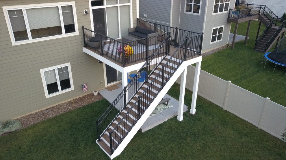 This is an example of a small transitional backyard and first floor deck in Minneapolis with with skirting, no cover and metal railing.