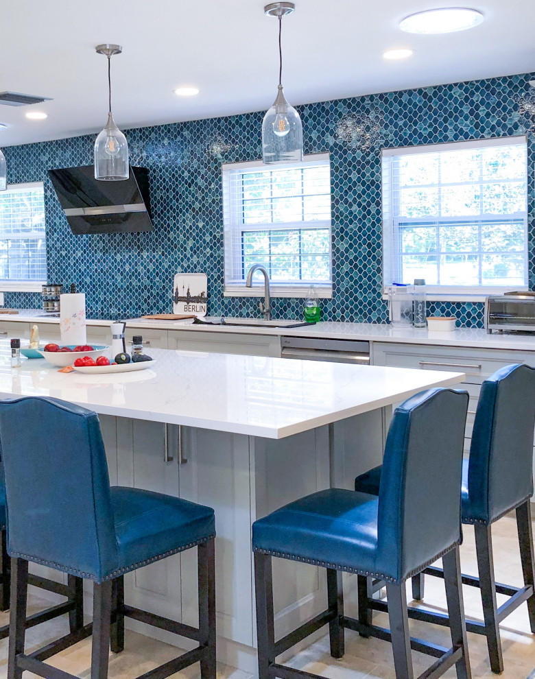 Inspiration for a transitional l-shaped separate kitchen in Tampa with an undermount sink, recessed-panel cabinets, white cabinets, quartzite benchtops, blue splashback, mosaic tile splashback, stainless steel appliances, with island, beige floor and white benchtop.