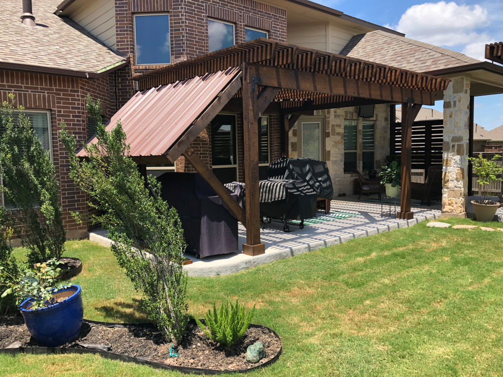 Design ideas for a large country backyard patio in Austin with a pergola.