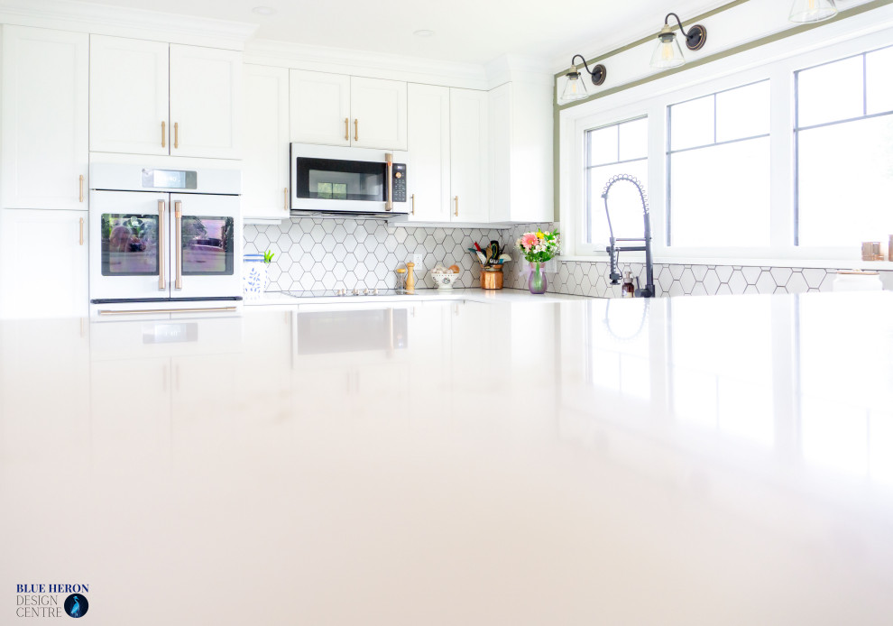Mid-sized transitional u-shaped laminate floor and gray floor eat-in kitchen photo with an undermount sink, shaker cabinets, white cabinets, quartz countertops, gray backsplash, ceramic backsplash, white appliances, no island and white countertops