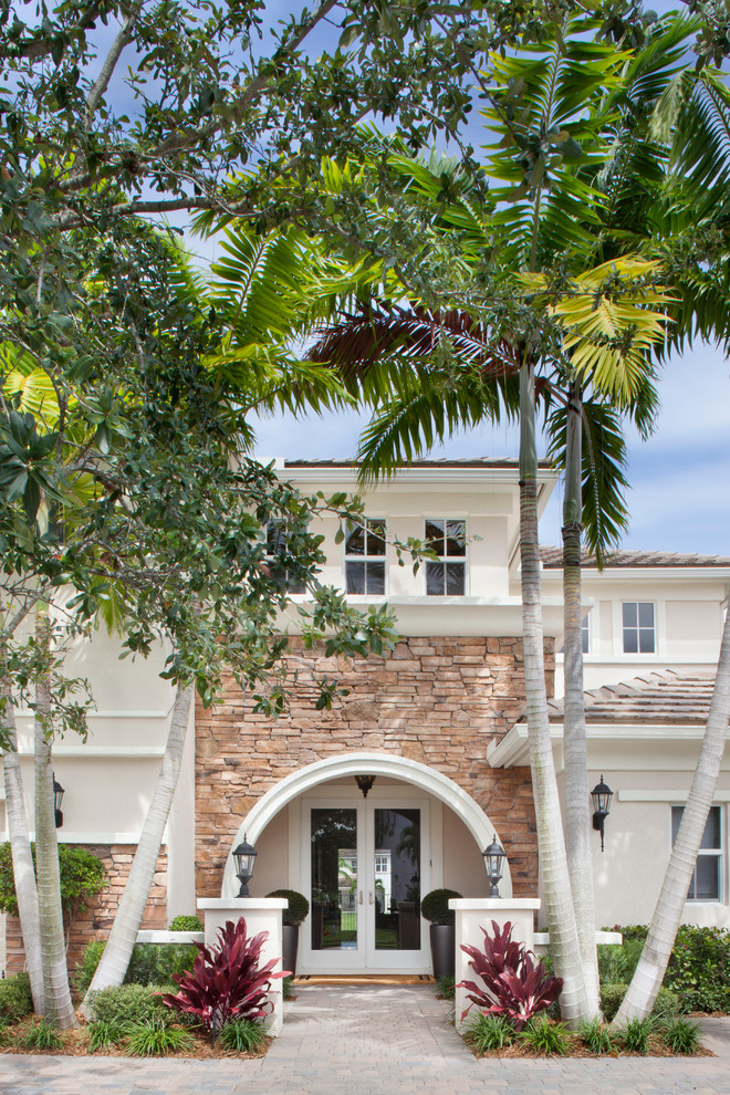 Inspiration for a large transitional front door in Miami with a double front door, a glass front door and beige walls.