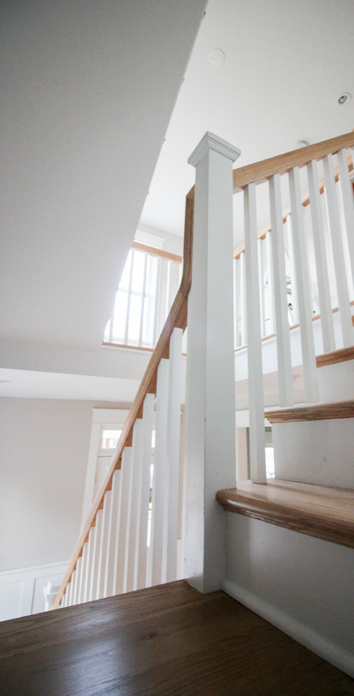 Large traditional wood l-shaped staircase in DC Metro with wood risers and wood railing.