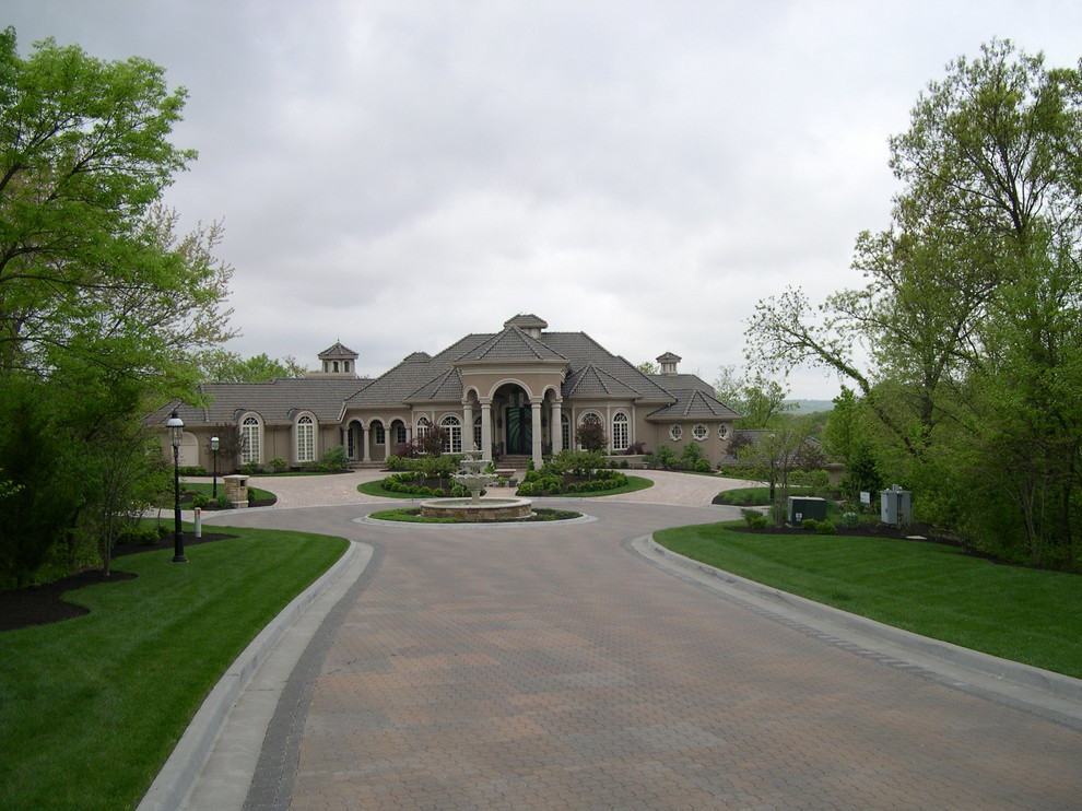 Expansive traditional front yard full sun driveway in Kansas City with a water feature and brick pavers.