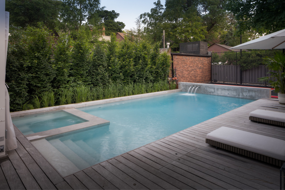 This is an example of a mid-sized industrial backyard rectangular pool in Toronto with with a pool and decking.