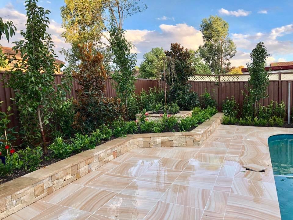 Design ideas for a mid-sized modern backyard full sun formal garden for summer in Sydney with natural stone pavers.