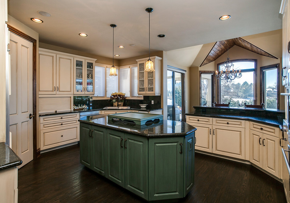 Design ideas for a mid-sized traditional u-shaped eat-in kitchen in Denver with a double-bowl sink, raised-panel cabinets, green cabinets, granite benchtops, black splashback, stone slab splashback, stainless steel appliances and dark hardwood floors.