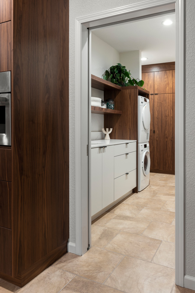 Inspiration for a mid-sized contemporary l-shaped ceramic tile and beige floor dedicated laundry room remodel in Sacramento with an undermount sink, flat-panel cabinets, dark wood cabinets, quartz countertops, a stacked washer/dryer and white countertops