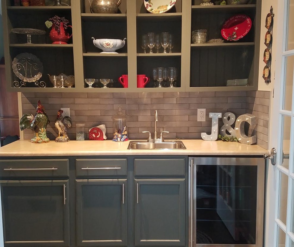 This is an example of a large transitional single-wall wet bar in Indianapolis with a drop-in sink, shaker cabinets, green cabinets, grey splashback and subway tile splashback.