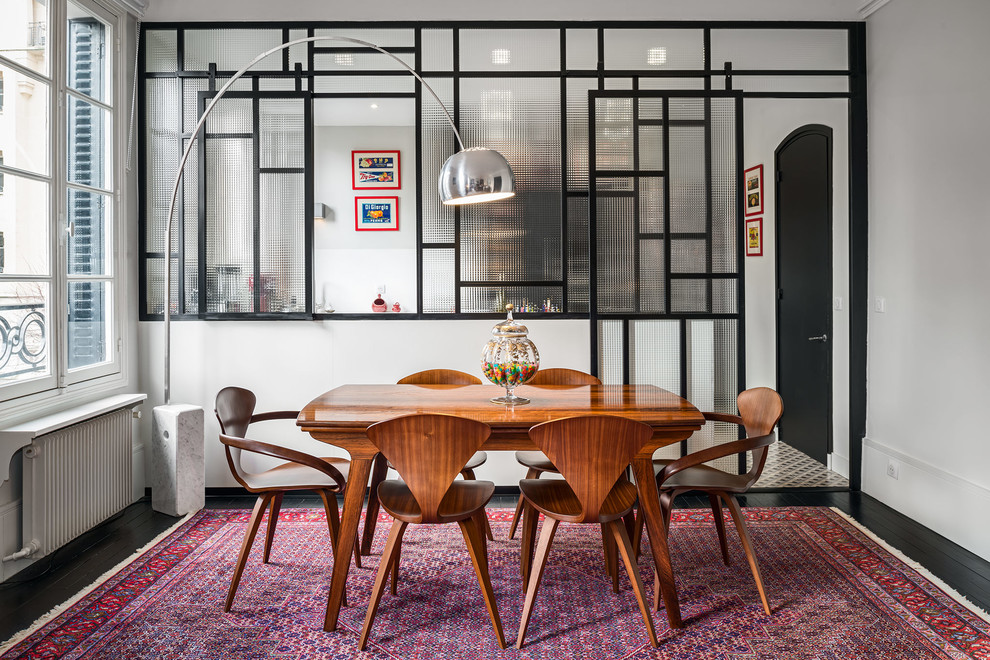 This is an example of a large eclectic open plan dining in Paris with white walls, painted wood floors, a standard fireplace and a stone fireplace surround.