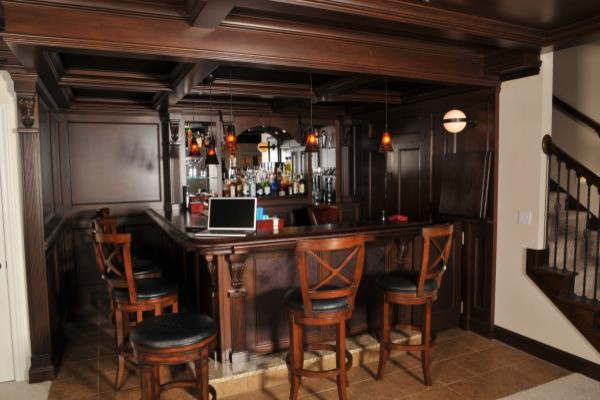 Inspiration for a mid-sized traditional l-shaped seated home bar in Columbus with dark wood cabinets and ceramic floors.
