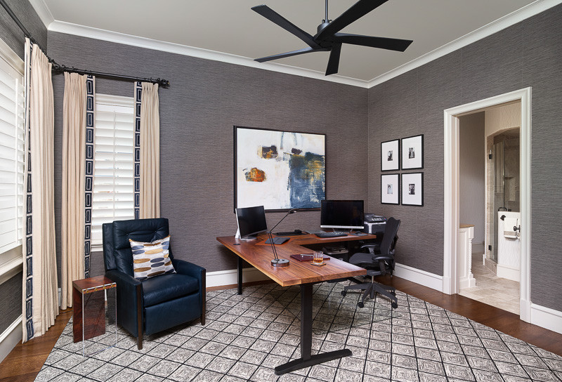This is an example of a medium sized eclectic study in Dallas with grey walls, medium hardwood flooring, no fireplace, a freestanding desk and brown floors.