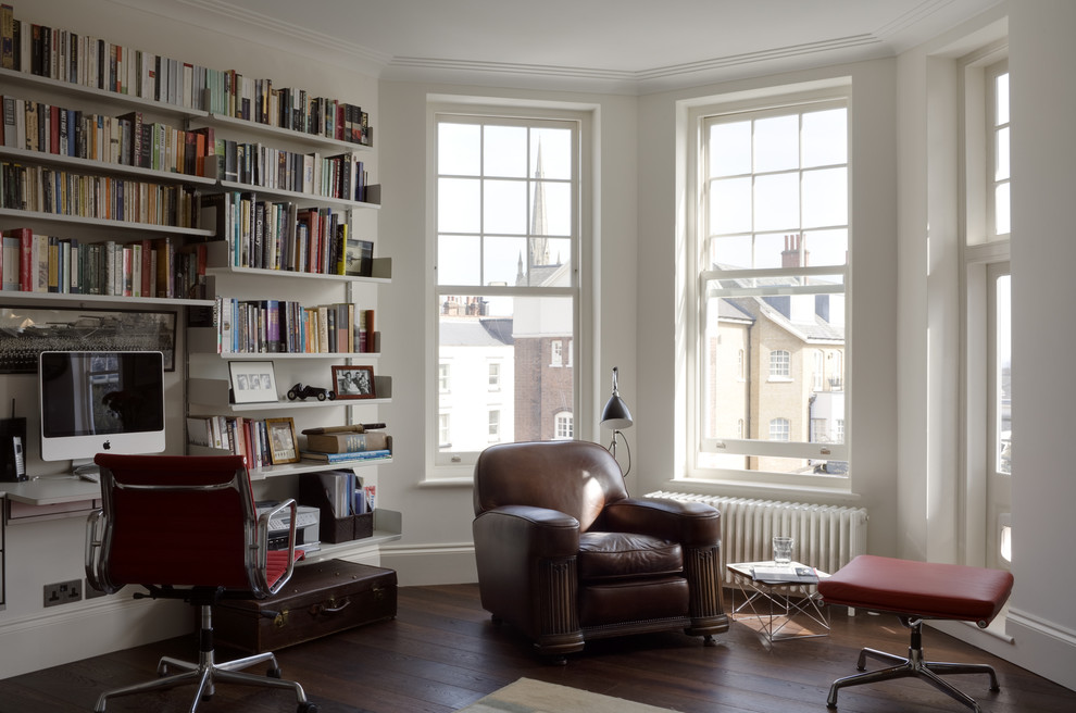 This is an example of a mid-sized midcentury enclosed living room in London with a library, white walls, dark hardwood floors, no tv and brown floor.