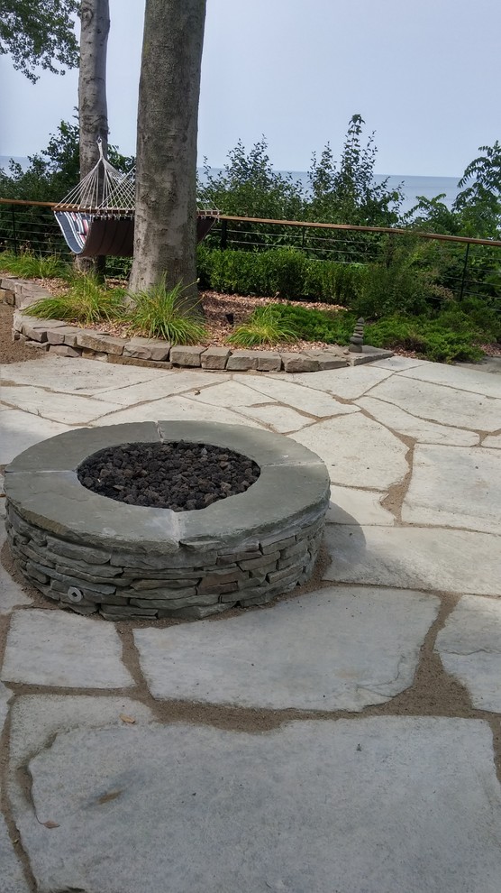 Mid-sized beach style backyard garden in New York with a fire feature and natural stone pavers.