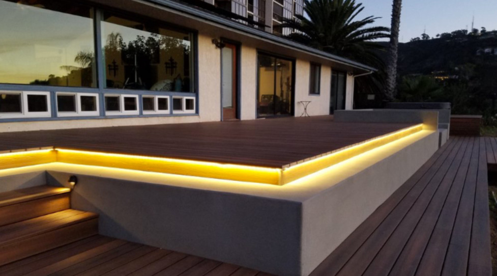 Example of a mid-sized minimalist backyard deck design in Orange County with a fire pit and no cover