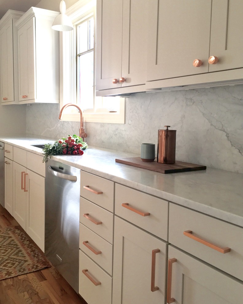 This is an example of a mid-sized transitional u-shaped kitchen in Phoenix with an undermount sink, shaker cabinets, white cabinets, marble benchtops, white splashback, stone slab splashback, stainless steel appliances, medium hardwood floors and with island.