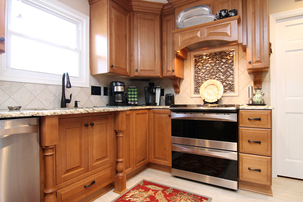 Example of a large transitional u-shaped porcelain tile eat-in kitchen design with an undermount sink, raised-panel cabinets, medium tone wood cabinets, granite countertops, beige backsplash, porcelain backsplash and stainless steel appliances